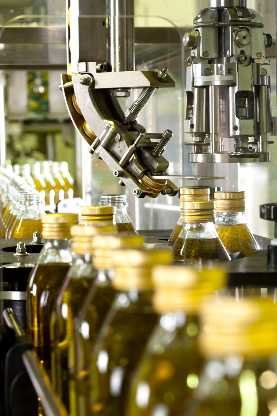 Glass bottles on industrial conveyor line requiring air blow-off solutions for drying and debris removal